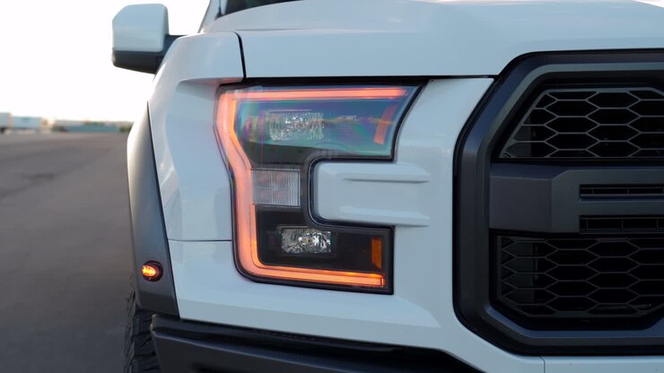 Dettagli cinematografici delle luci su un camion Ford Raptor al crepuscolo caldo e colorato del tramonto in Alberta, Canada