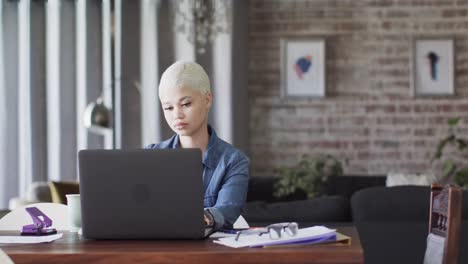 Vielbeschäftigte-Biracial-Frau,-Die-Zu-Hause-Mit-Laptop-In-Zeitlupe-Arbeitet