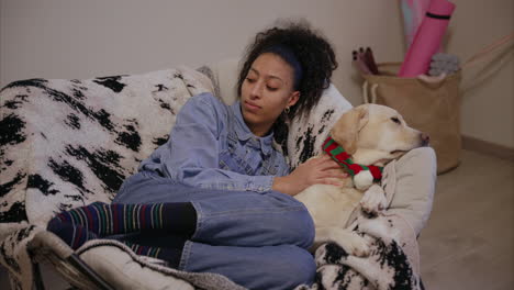 woman lying on a rocking chair caresses her dog and talks, puppy with cute scarf relaxing with owner, gentle pure breed, labrador retriever chilling at home, dog mom, pet parenting, daycare, pure love