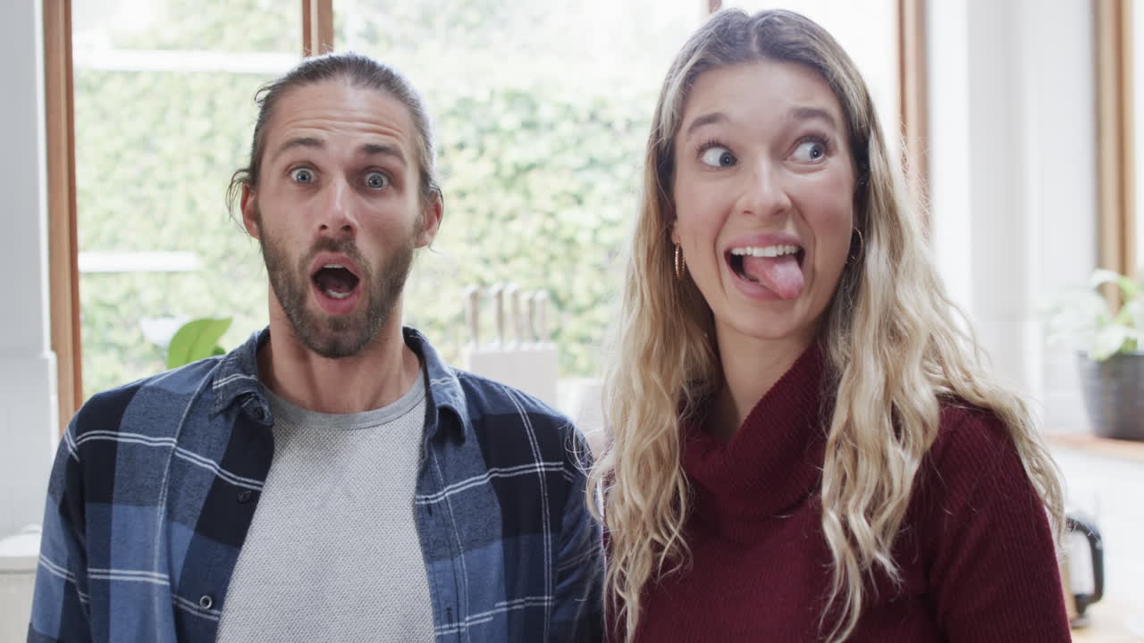 retrato de um casal feliz e diversificado na cozinha em casa, em câmara lenta