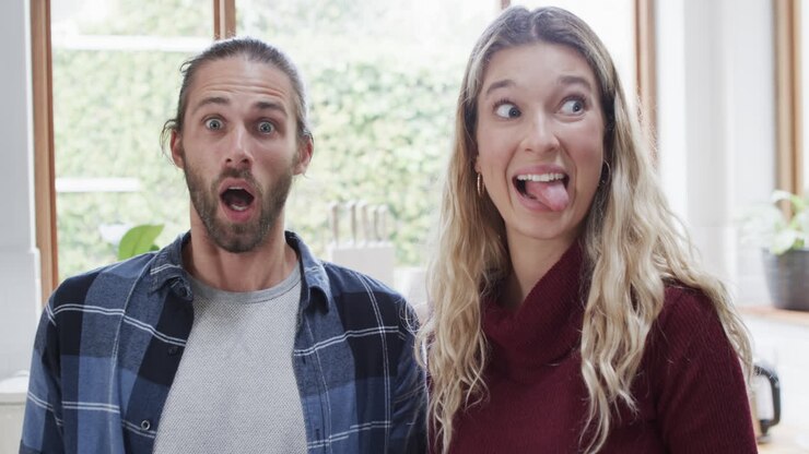 Portrait of happy diverse couple in kitchen at home, in slow motion