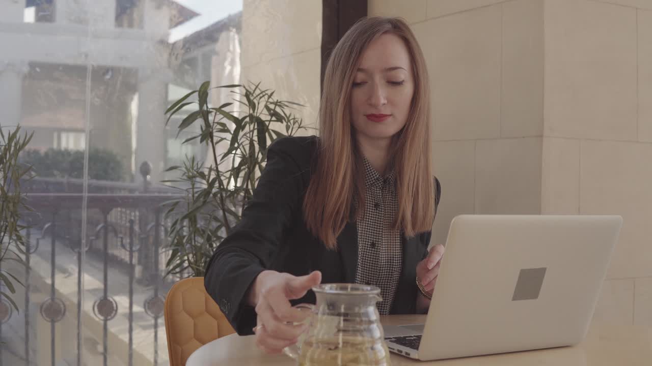 Donna che lavora su un computer portatile in un caffè
