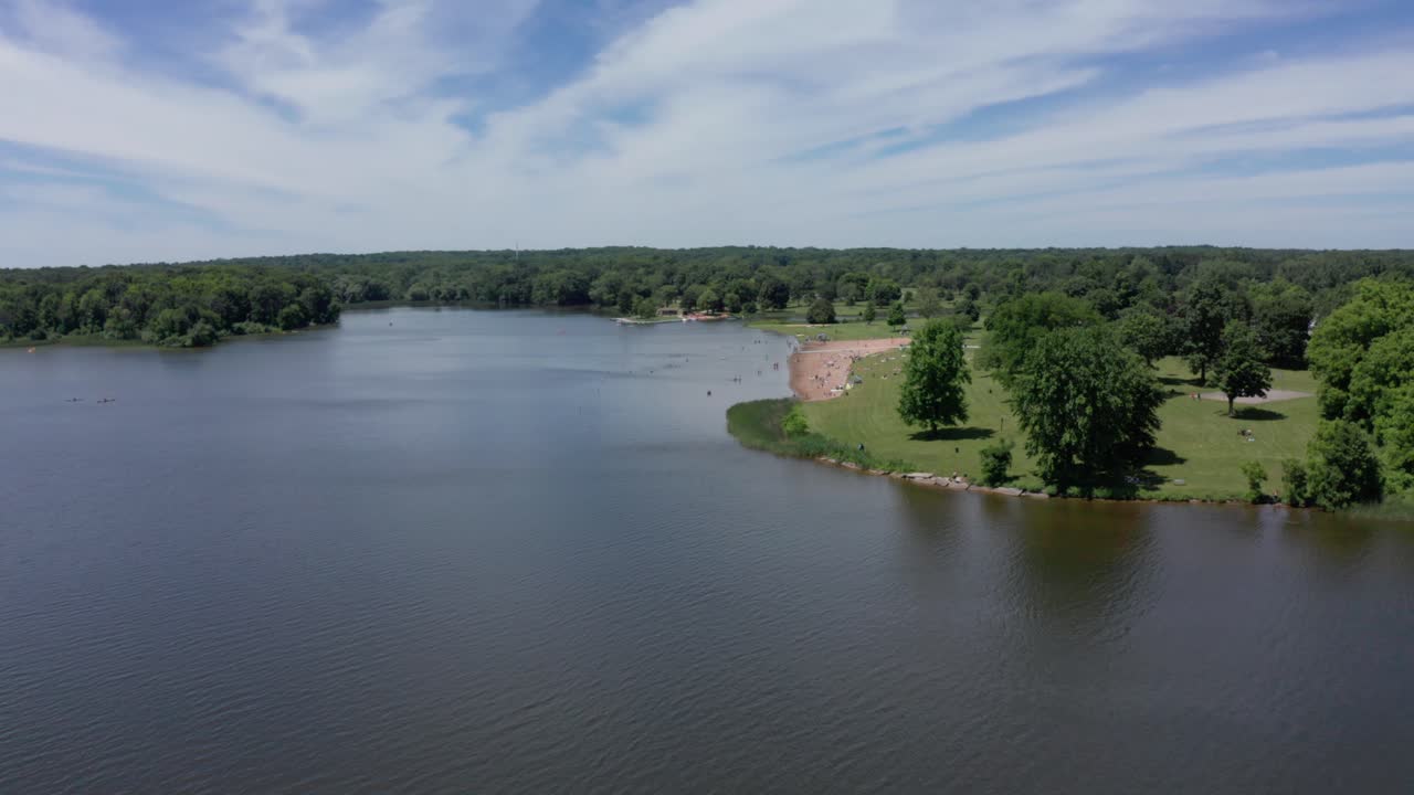 Drone Footage of Lake in Michigan in Summer with people on beach and a volleyball court