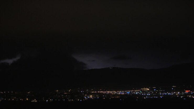 Città notturna illuminata e lampi di fulmine