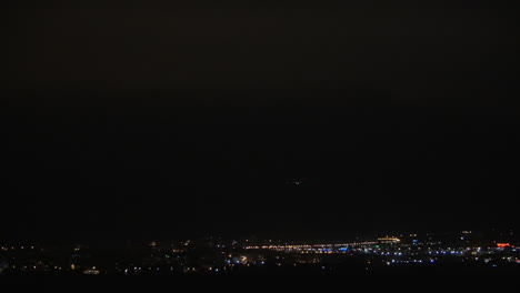 illuminated night city and lightning flashes