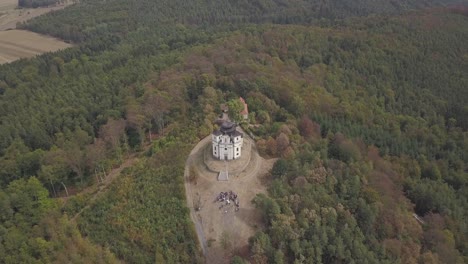 drone shot, camera movement towards the catholic church and continue beyond that during the wedding ceremony on the hill