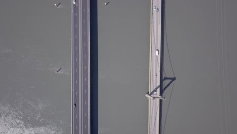 Vista-De-Arriba-Hacia-Abajo-De-Los-Vehículos-Que-Cruzan-El-Río-Ródano-Por-Un-Puente-En-Roquemaure,-Francia