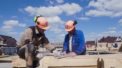 bauarbeiter messen holz bei einem hausrahmenprojekt