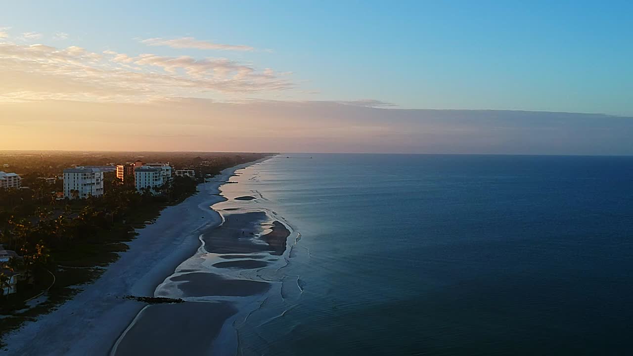 volando alto sobre la costa del golfo en nápoles florida con un hermoso amanecer