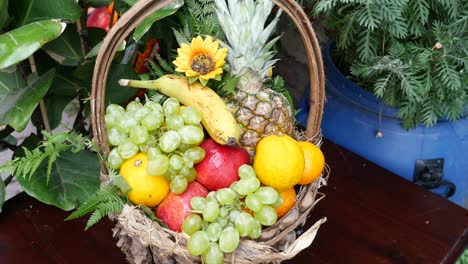 a beautiful fruit basket with pineapple, banana, grapes, apple, and orange