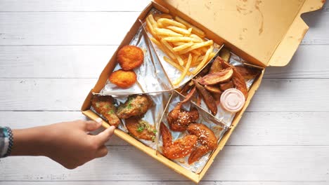 pollo frito, papas fritas y patatas en una caja combinada