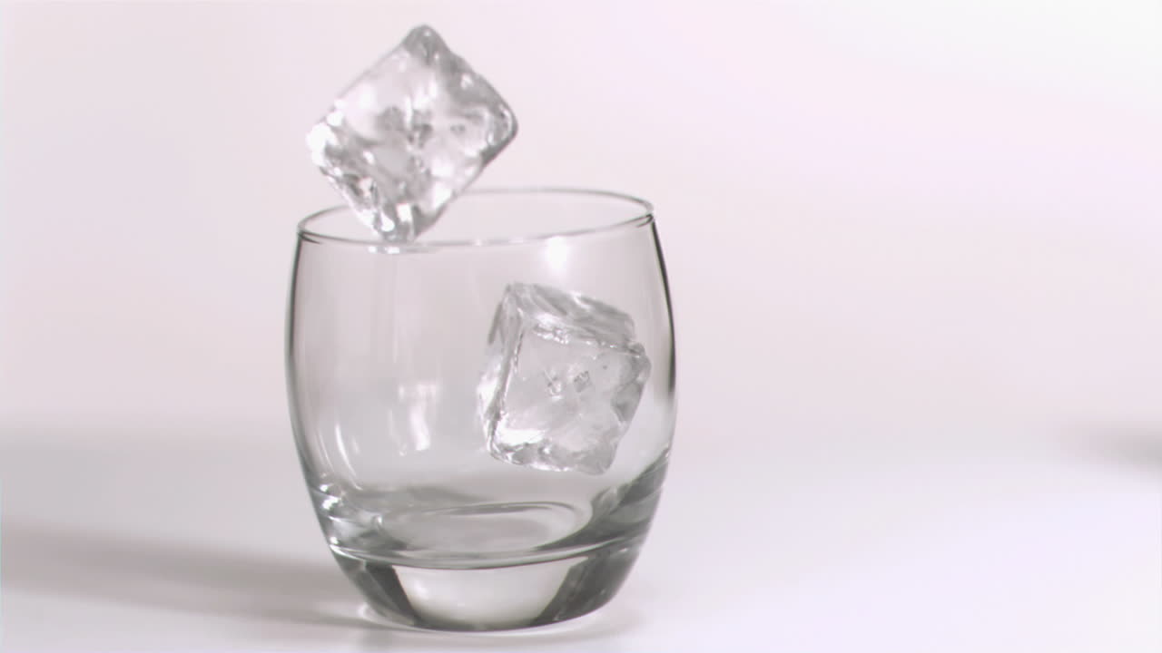 cubos de hielo rodando en súper cámara lenta en un vaso