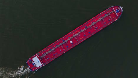 aerial view of red cargo ship navigating on calm dark waters