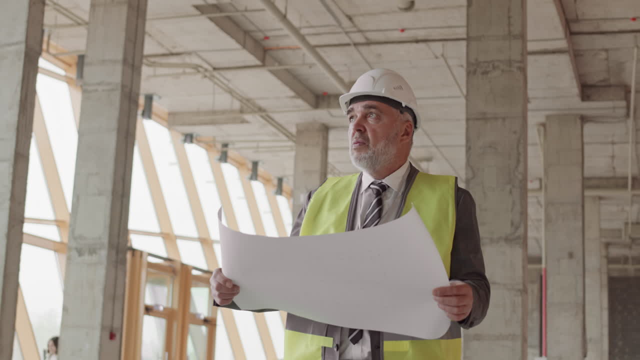 Foreman Walking in Building with Plan