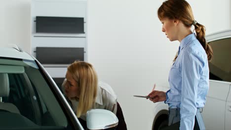 women discussing a car purchase in a showroom