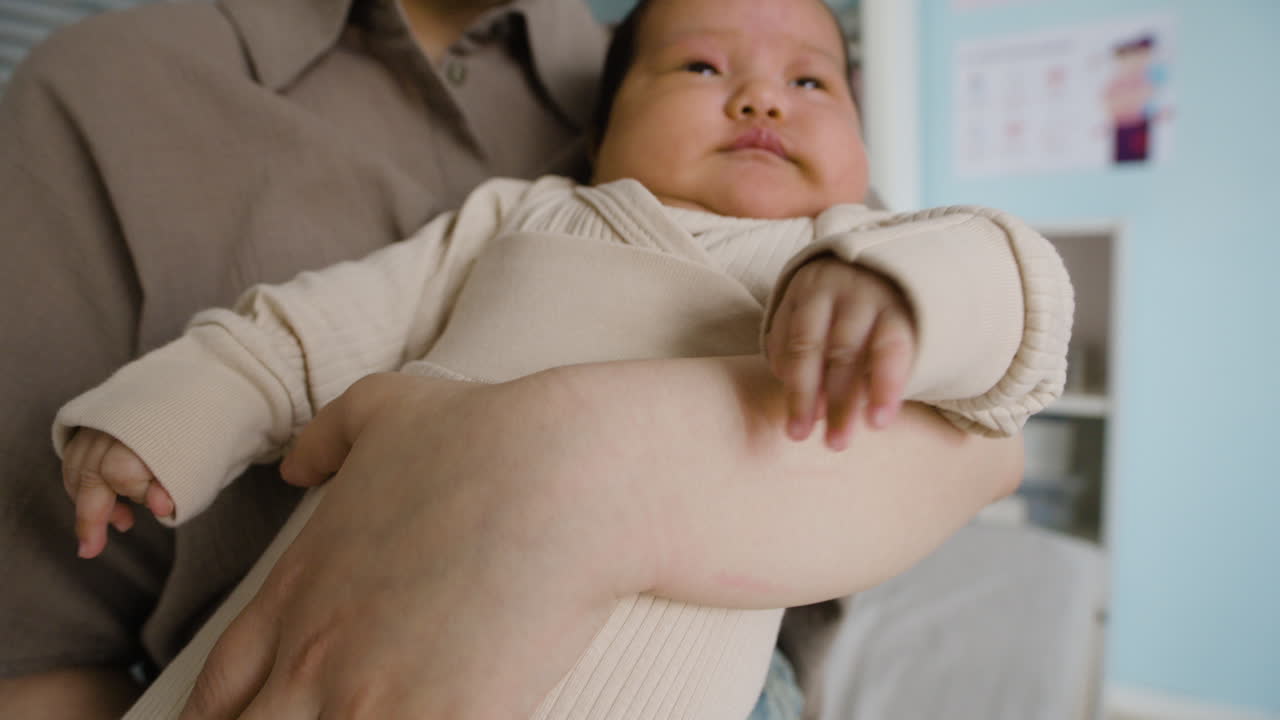 Images of a baby being held by their mother