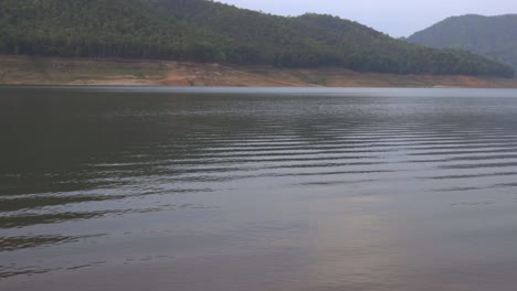 Toma-Panorámica-Del-Indicador-De-Nivel-De-Agua-Amarillo-Con-Vista-Al-Lago-Y-La-Cordillera-En-Un-Día-Nublado-En-Un-Parque-Nacional-En-Chiang-Mai,-Tailandia