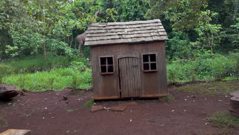 a rustic wooden hut in a lush green forest