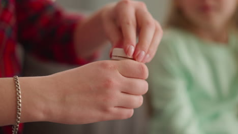 woman opens bottle with golden paint little girl sits nearby