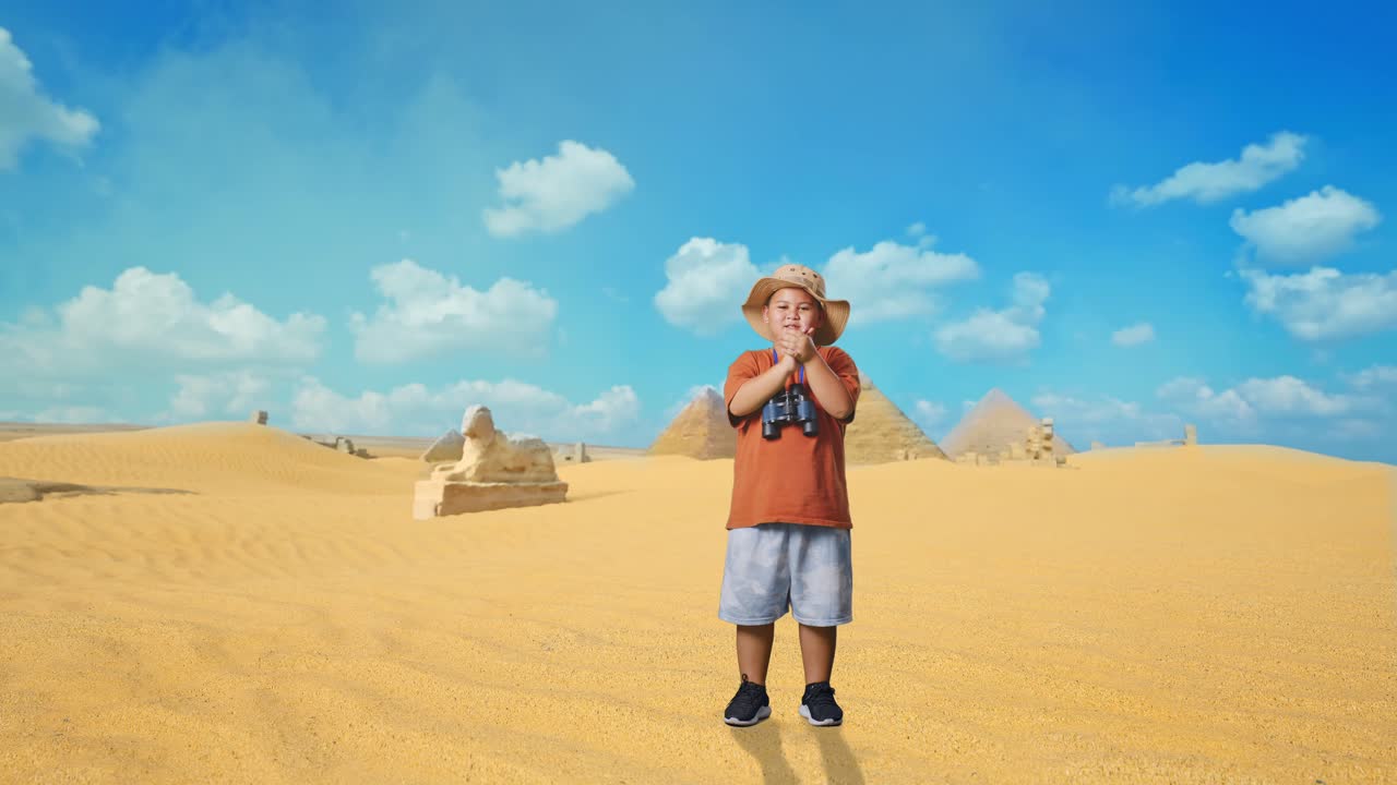 Asian Boy With A Hat Clapping Hands After Looking Through The Binoculars. Boy Researcher Examines Something While Traveling In Giza Pyramid, Travel Tourism Adventure Concept, Full Body