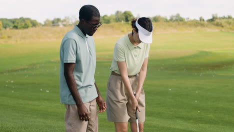 caucasian woman and african american man on the golf course.