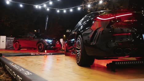 two black mercedes-amg cars on display at night