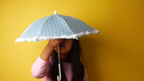 child with a blue dotted umbrella