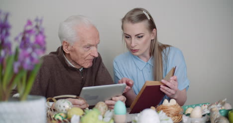 mujer joven navegando por internet con el abuelo en la tableta digital 3