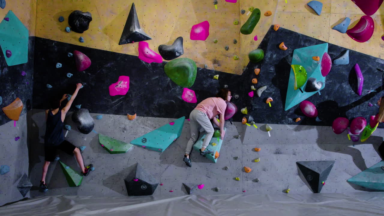 adolescentes haciendo bouldering en un gimnasio