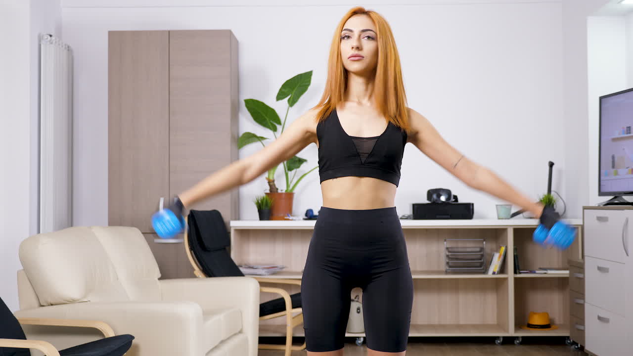 아령으로 집에서 운동하는 여자