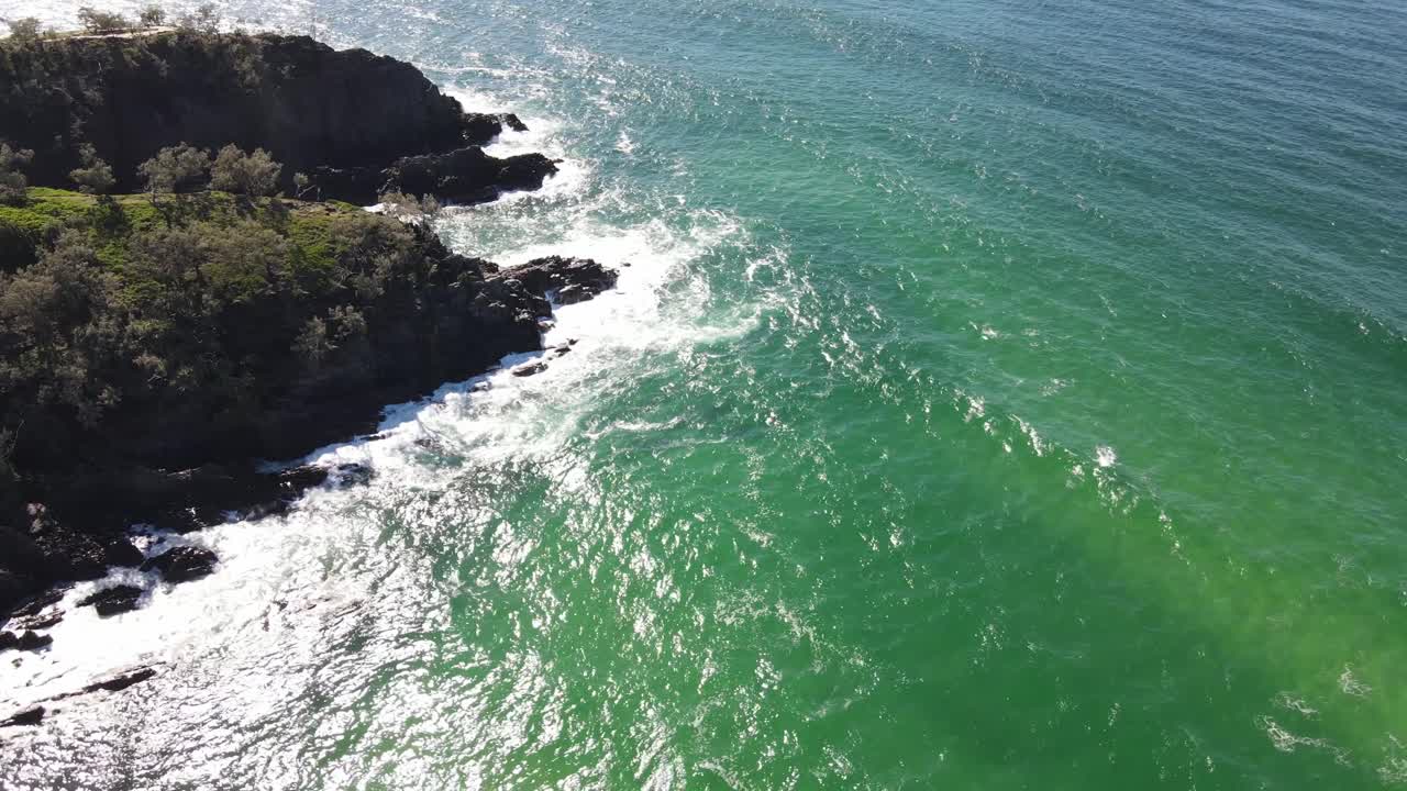 Aerial drone view of blue-green ocean beside parkland in Noosa, Queensland, Australia