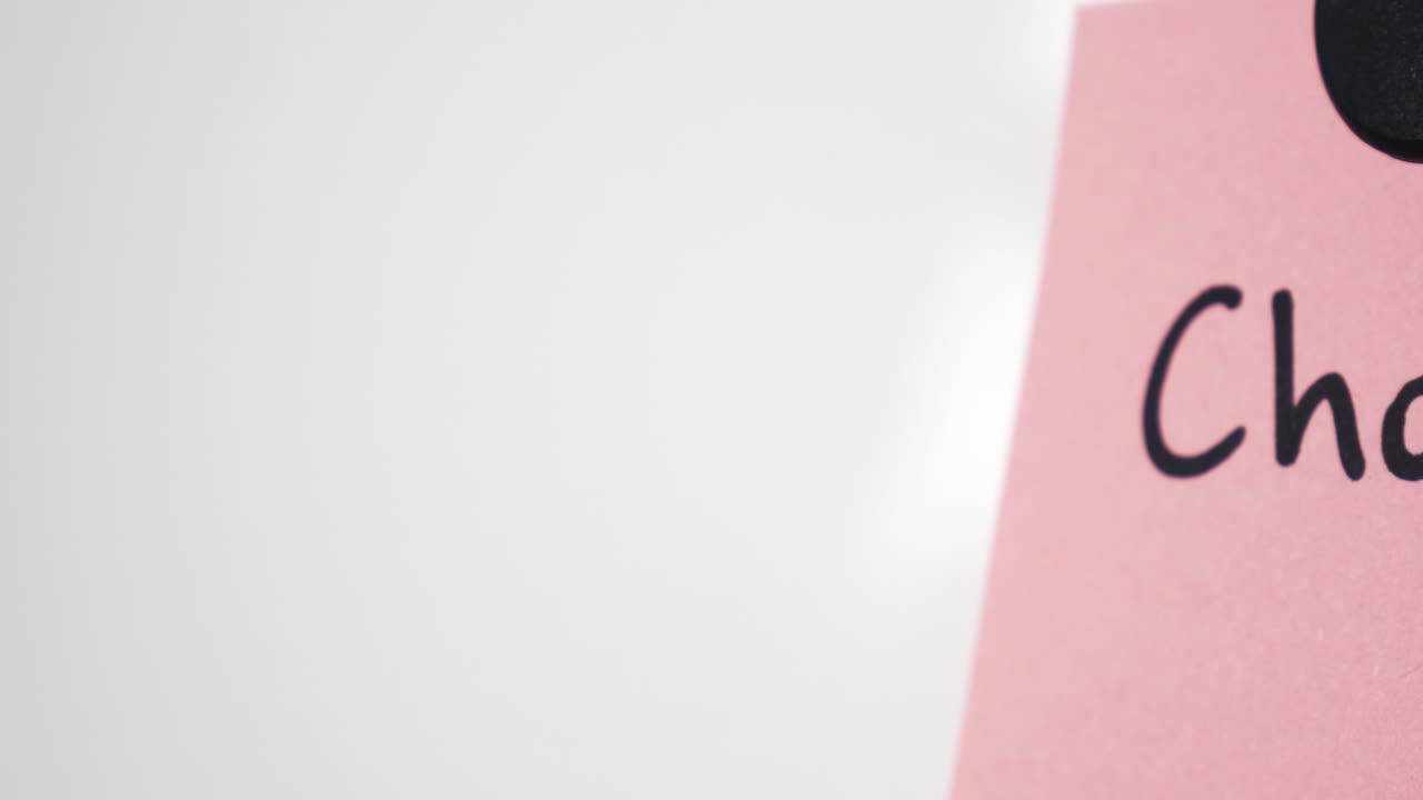 Panoramica su testo di beneficenza su una nota rosa tenuta da un magnete su una lavagna bianca con messa a fuoco selettiva