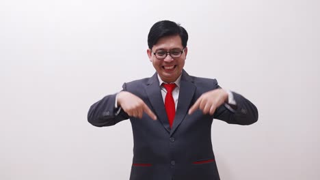 happy asian businessman pointing above and down then showing thumbs up okay hand gesture