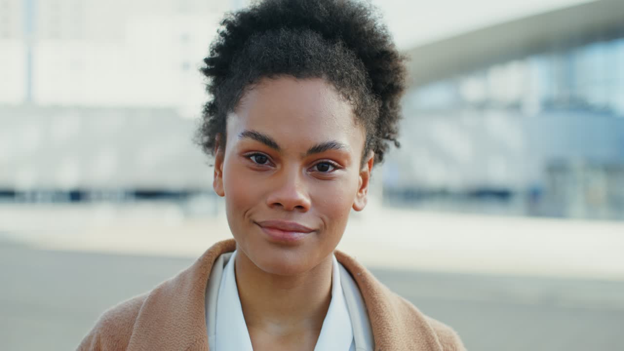 mujer afroamericana sonriente en un entorno urbano
