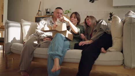 amigos abriendo un regalo en un sofá