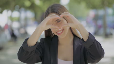 girl showing hand heart and smiling at camera