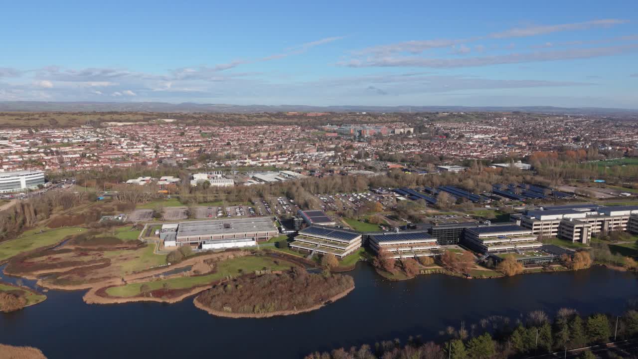Riprese aeree con drone di Portsmouth da lontano, inquadrando l'area urbana dall'ospedale alla M27 con viste sulla campagna distante, proprietà sul lungomare residenziali e commerciali in una luminosa giornata di sole.