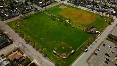 aerial over green athletic fields on a sunny day in port alberni, british columbia, canada