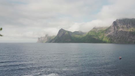 Speedboat-On-Buoyant-Near-the-Sea-Shore-In-Anderdalen-National-Park,-Senja-Island,-Norway-With-Mountains-In-The-Background