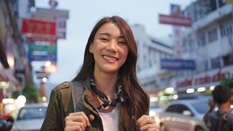 smiling woman traveler on city street at night