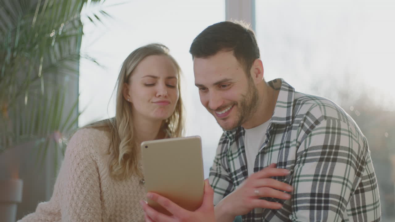 una pareja caucásica mirando la tableta.