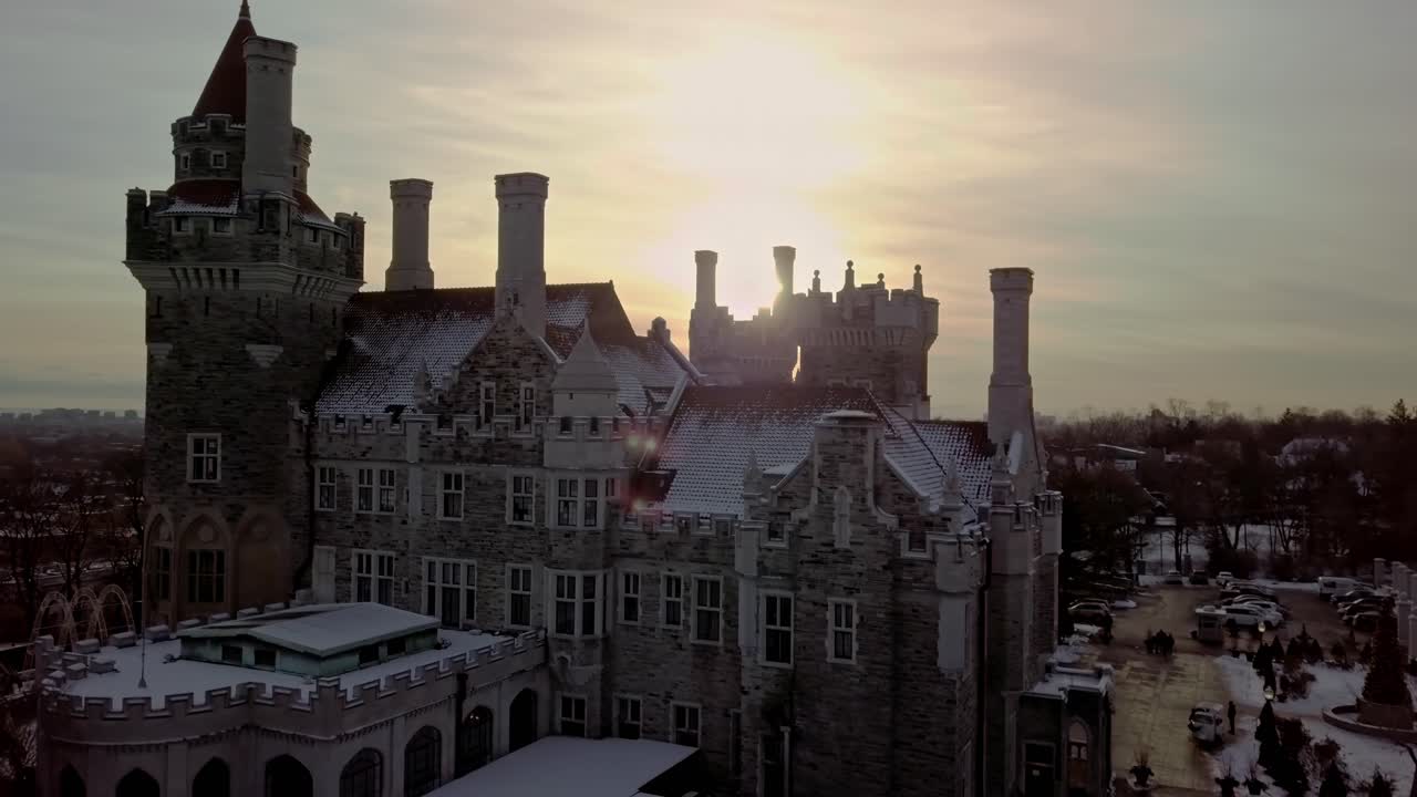 Dramatic Drone Reveal of Beautiful Snowy Castle near Sunset, Wide Pan. Charming Scenic Landmark in Toronto Ontario Canada, Aerial Establishing Shot Pedestal Up
