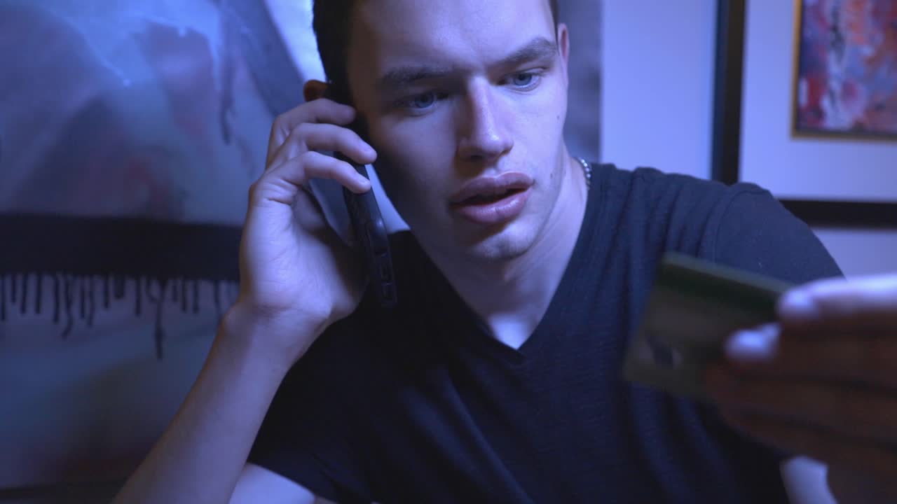 кавказский мужчина разговаривает по смартфону и сообщает данные своей кредитной карты