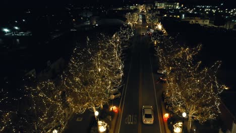 Luces-Navideñas-En-Un-Pequeño-Pueblo---La-Vista-Aérea-Ascendente-Revela-Las-Luces-De-La-Calle