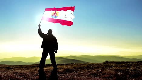 exitoso hombre silueta ganador agitando bandera de la polinesia francesa en la parte superior del pico de la montaña. fondo de bucle cinemagraph