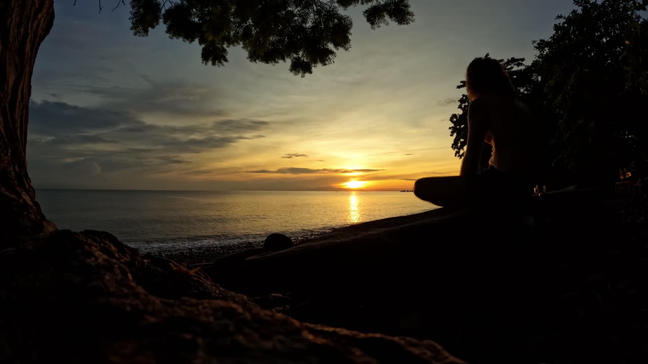 silueta de hombre timelapse en puesta de sol sobre la playa y colorido cielo dramático nubes en movimiento