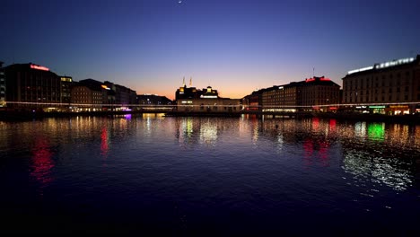 geneva city at night with lights reflecting in lake geneva