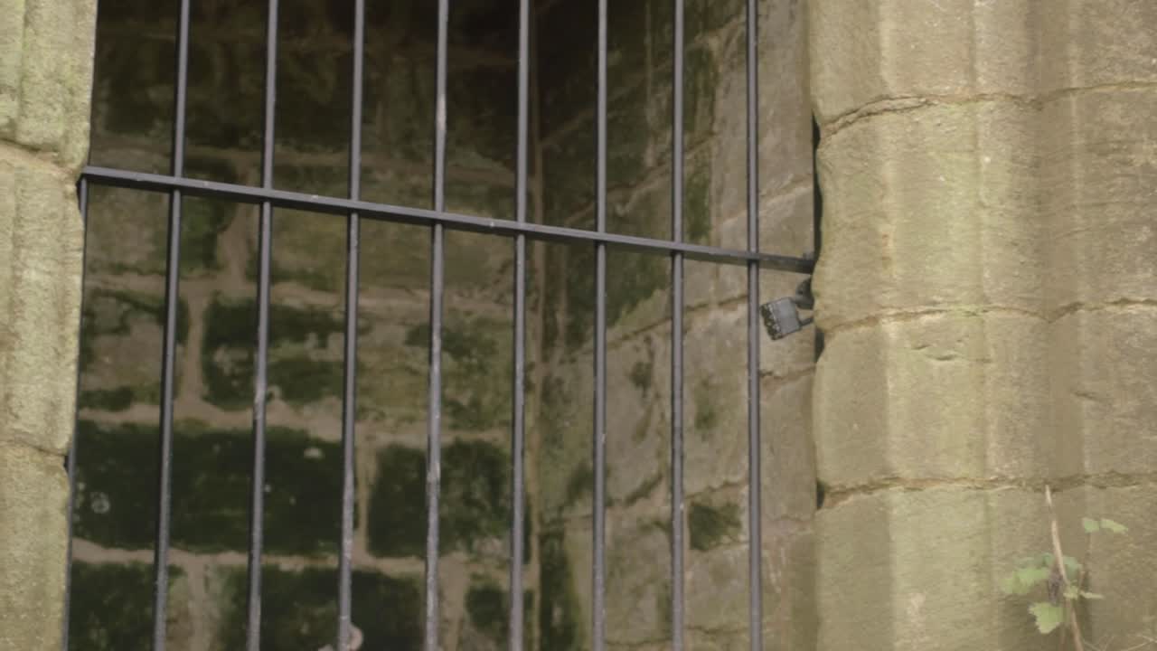 Metal bars outside doorway of old stone dungeon