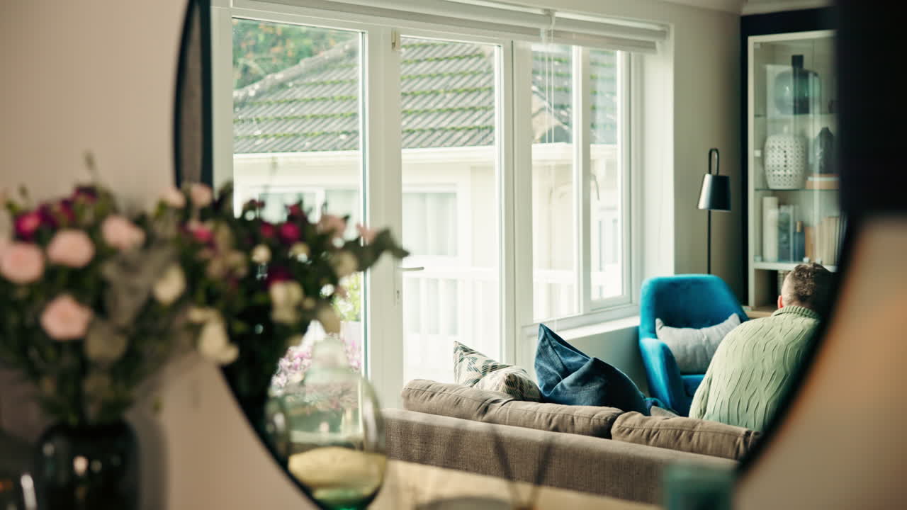 Man Talking on Phone and Holding Tablet in Living Room