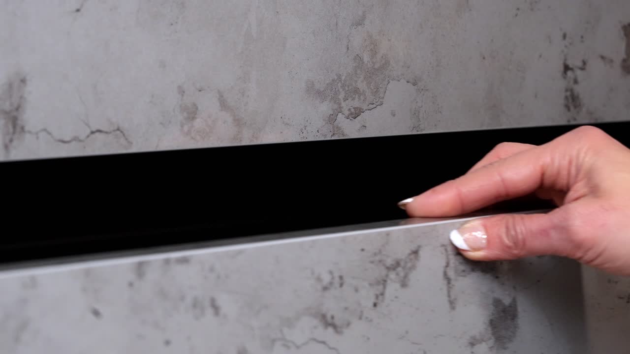 mujer con uñas pintadas abre y cierra el cajón del armario